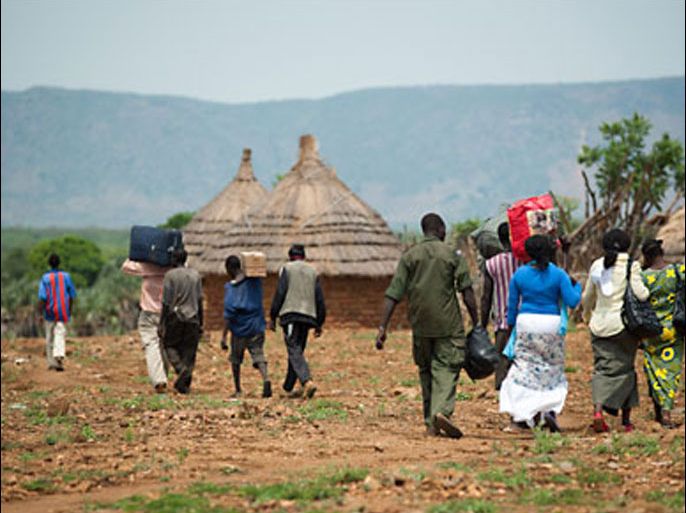 Men and women in the Nuba mountains of Sudan's South Kordofan region carry their belongings as they flee bombing by the Sudanese army on June 28, 2011