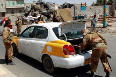 Defected army soldiers search a car at a checkpoint on a street in Sanaa June 6, 2011. Yemenis celebrated on Monday what many hope will be a new era without President Ali Abdullah Saleh, now recuperating in Saudi Arabia after an operation to remove shrapnel from his chest a day earlier.