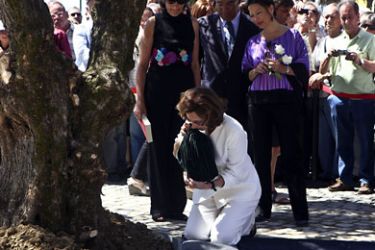 epa Jose Saramago's widow Pilar del Rio (Front), kneels to place ashes of late Portuguese writer and Nobel Prize for Literature in 1998, around an olive tree brought from his homeland, Azinhaga do Ribatejo, one year after Saramago's death, in Lisbon, Portugal, 18 June 2011