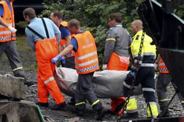 r_Rescue teams carry the body of a victim after transporting it by ferry from Utoeya island to Sundvollen, northwest of Oslo July 24, 2011
