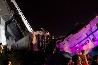 Wenzhou, Zhejiang, CHINA : Onlookers gather at the site of a high-speed train accident on July 23, 2011, near Wenzhou. Two train cars derailed and fell off a bridge after the train, already crippled by a lightning strike, was hit from behind by another express, according to state media reports. The train, which was travelling between the eastern Chinese cities of Wenzhou and Hangzhou