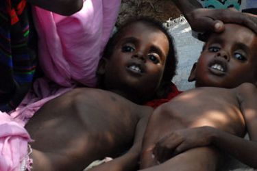 SOMALIA : Two Somali children suffering from malnutrition lie at a camp for Internally Displaced People (IDP) near Mogadishu airport on July 18, 2011. The IDP's at the camp are facing dire humanitarian crises including lack of proper shelter, clean water, medicine and sufficient food for