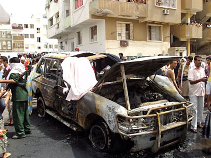 f_Yemenis look at a destroyed vehicle following a car bomb in the main southern Yemeni city of Aden on July 20, 2011, in which the police say a Briton who was the head of a shipping