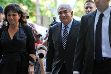 Former IMF chief Dominique Strauss-Kahn(C) arrives with his wife Anne Sinclair at the New York courthouse on August 23, 2011 before a judge dropped charges against him of sexually assaulting hotel maid Nafissatou Diallo