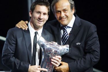 FC Barcelona's Argentinian forward Lionel Messi (L), poses with his trophy for football's Best Player in Europe 2010/2011, flanked by UEFA President French former football player Michel Platini, on August 25, 2011, after the draw for the UEFA 2011-2012 Champions League in Monaco. AFP PHOTO SEBASTIEN NOGIER