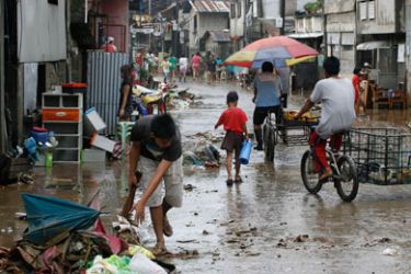 Residents clean up after flooding in Marikina City, Metro Manila September 28, 2011. The Philippines began on Wednesday the clean-up of flooded areas and assessments of damage, including to the key rice crop, a day after Typhoon Nesat left behind at least 18 dead.