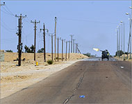 ثوار ليبيا يطلقون النار من إحدى العربات باتجاه أنصار للقذافي قرب سرت (الفرنسية)