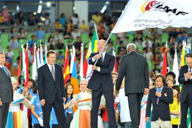 afp-Valentin Balakhnichev, president of the All-Russia Athletics Federation, waves the IAAF flag during a handover ceremony