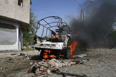 r_A soldier lies dead as a police vehicle burns at the site of a double suicide bombing in Quetta September 7, 2011. Two suicide bombers targeting a senior security official struck near government offices in the southwestern