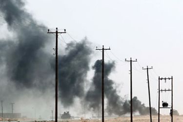 Smoke billows near the frontline as fighting rages between Libyan National Transitional Council (NTC) fighters and regime loyalists in the outskirts of Bani Walid on September 28, 2011