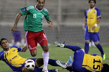 ف-Jordan's Al-Wehdat club player Amer Deeb (C) runs with the ball past Ali Bahjat Fadhil (R)