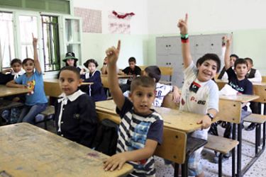 r_Students raise their hands in a classroom on the first day of a new school term in Tripoli September 17, 2011. REUTERS