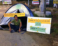 فلسطيني يشارك في الاحتجاجات بإسرائيل ويرفع شعارات بالعربية والعبرية