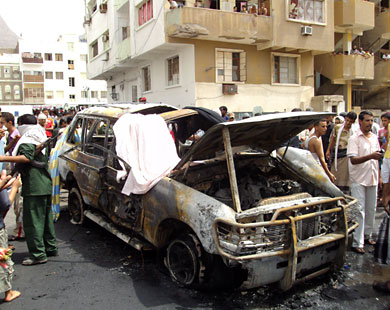 مواطنون يتفقدون آثار تفجير سابق لسيارة مفخخة بمدينة عدن (الفرنسية) 
