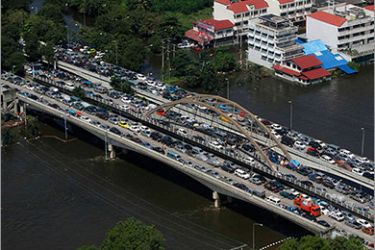 An aerial view of residents and vehicles being evacuated from a flooded area on a bridge in Ayutthaya province October 10, 2011. About 261 people have died since late July in flood-related incidents, the Department of Disaster Prevention and Mitigation said. Some 2.3 million people have been affected in the worst flooding