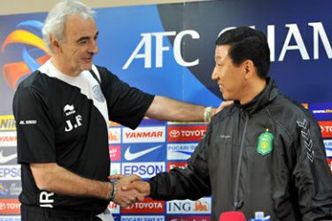 ف-South Korea's Jeonbuk Hyundai Motors coach Choi Kang-Hee (R) shakes hands with Qatar's Al Sadd coach Jorge Fossati (L)