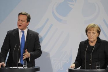British Prime Minister David Cameron speaks next to German Chancellor Angela Merkel (R) as they address journalists before their meeting on November 18, 2011 at the chancellery in Berlin. Cameron, whose country is a non-eurozone member, met Merkel amid sharp differences over handing more central power to Brussels as the eurozone tackles its debt crisis.