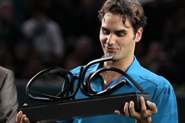 لإ-Swiss Roger Federer celebrates with his trophy after winning against French Jo-Wilfried Tsonga their Paris
