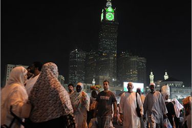 Muslim piligrims walk in front of the clock tower of Mecca after performing the evening prayer in the holy city's Grand Mosque on November 2, 2011. The annual Islamic hajj brings Meccans the opportunity to cash in on the influx of pilgrims, tempting homeowners to move out and rent their houses for handsome returns. AFP PHOTO/FAYEZ NURELDINE