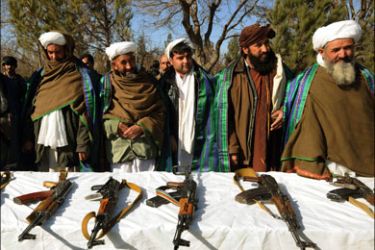 afp : Taliban fighters stands near their weapons after they joined Afghanistan government forces during a ceremony in Herat on December 29, 2011. Eleven fighters left the Taliban to join government forces in western Afghanistan. AFP PHOTO/Aref KARIMI