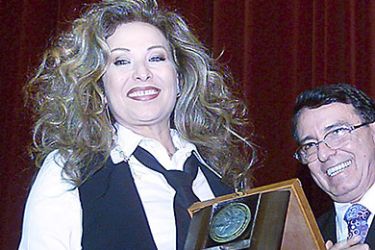 epa00860022 Syrian actress Raghda with a trophy given to her at the end of 10-day deliberations of the Damascus Theater Festival late Friday, 10 November 2006 in Damascus. EPA/YOUSSEF BADAWI