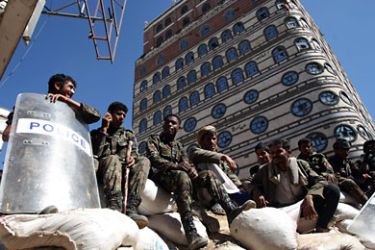 Yemeni military policemen sit on sandbags near the Asser roundabout as a military commission began to remove checkpoints and barricades erected during months of deadly protests in Sanaa on December 17, 2011. AFP PHOTO/ MOHAMMED HUWAIS