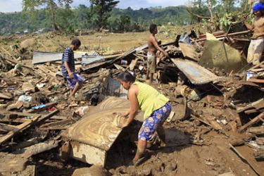 Villagers retrieve belongings in the ruins of their houses, which were swept away by flashfloods brought by Typhoon Washi, in Cagayan de Oro, southern Philippines December