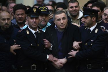 Italian policemen escort Michele Zagaria (C), the boss of the Casalesi clan outside the Police's headquarters in Caserta following his arrest on December 7, 2011. Italian police on Wednesday arrested Michele Zagaria, 53, the most senior boss of the Camorra mafia still at large, digging through a secret bunker near Naples to end his 16 years on the run.