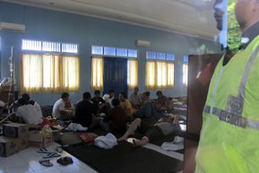 A port security officer guards injured people, at a temporary shelter in Trenggalek, who were rescued after their boat sank in East Java December 18, 2011. At least 217 people were missing, and possibly scores more, after the overcrowded boat packed with illegal immigrants heading for Australia sank in heavy seas overnight off the coast of east Java in Indonesia, authorities said on Sunday