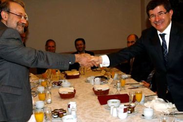 parliament speaker Ali Larijani (L) shakes hands with Turkish Foreign Minister Ahmet Davutoglu during a breakfast meeting in Ankara on January 12, 2012.