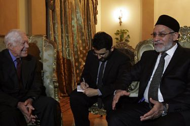 Mohammed Badie, head of Egypt's Muslim Brotherhood, (R) speaks with former US president Jimmy Carter during a meeting in Cairo on January 12, 2012. The Carter Center is one of the few monitoring groups to have had a licence to