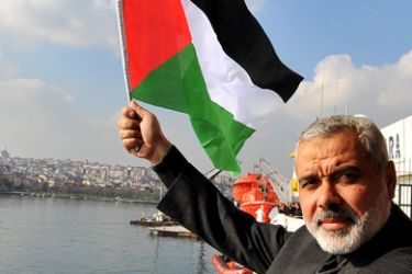 Gaza's Hamas prime minister Ismail Haniy waves a Palestinian flag during his visit on board the Turkish passenger ship Mavi Marmara in Istanbul, on January 2, 2012.
