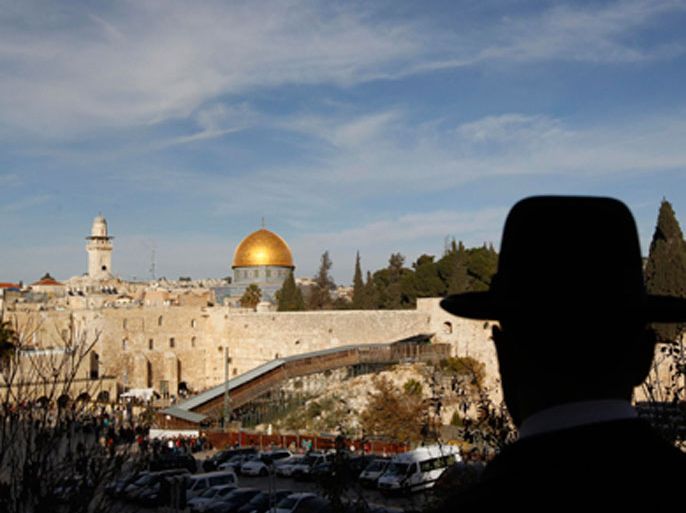 An ultra-Orthodox Jewish man stands at a view-point overlooking a wooden ramp (C) leading up from Judaism's Western Wall to the sacred compound known to Muslims as the Noble Sanctuary and to Jews as Temple Mount, where the al-Aqsa mosque and the Dome of the Rock shrine stand, in Jerusalem's Old City December 12, 2011.