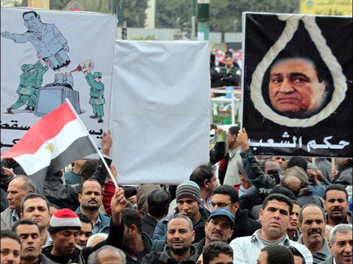 epa03069192 Egyptian protesters hold placards depicting the former Egyptian President Hosni Mubarak with a hanging rope (R), an other one (L) shows soldiers fixing a Mubarak broken statue, during a protest mamed 'Friday of martyrs dreams', in Tahrir square, Cairo, Egypt, 20 January 2012. According to media reports, dozens of protesters gathered in Tahrir square on 20 January. The protest is a preambule to the 25 January revolution's anniversary. EPA/KHALED ELFOQI