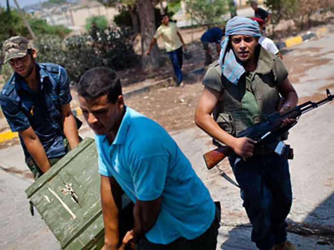 AUGUST 26: Libyan Rebel soldiers loot weapons from an ex-Gaddafi military compound as they advance their position towards pro-Gaddafi loyalists on August 26, 2011 in Tripoli, Libya. Heavy fighting continues in the Libyan capital between Colonel Gaddafi's forces and the surging rebel presence. Gaddafi's hometown of Sirte is today being targetted by British Tornado jets' precision-guided missiles.