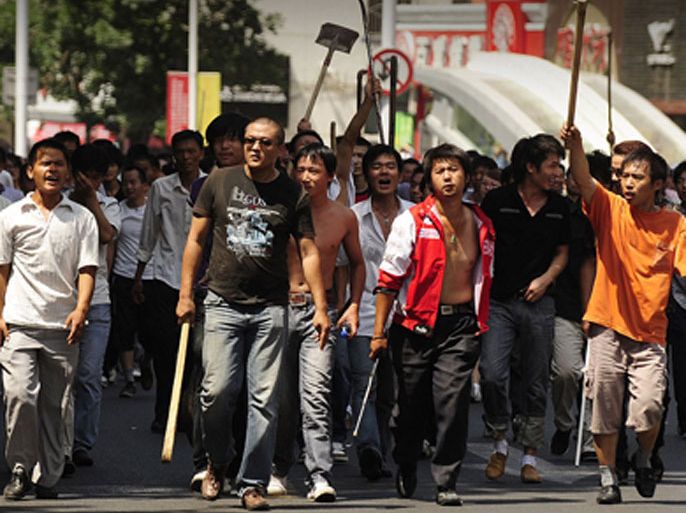 In this file picture taken on July 7, 2009, a large group of Han Chinese walk up a street carry sticks and shovels on the streets in Urumqi in China's far west Xinjiang province
