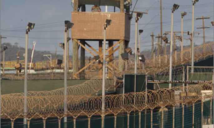 In this photo reviewed by US military officials, a US military member mans one of the watch towers at Camp Delta at the US Detention Center in Guantanamo Bay, Cuba on March 30, 2010.