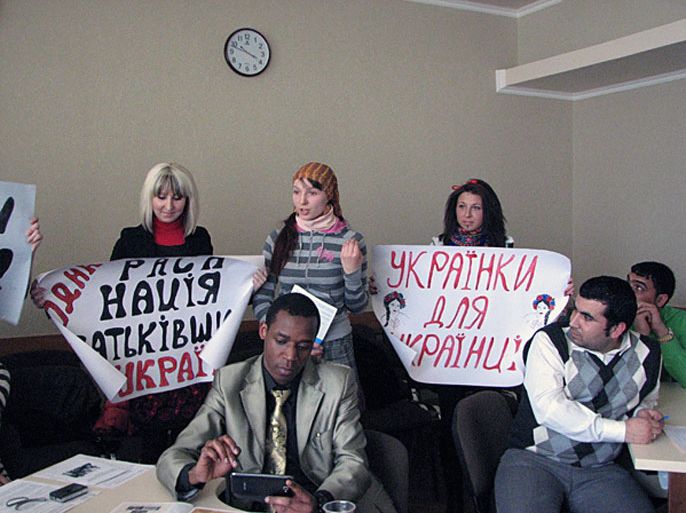 فتيات عنصريات يحملن شعارات تطالب بتحرير أوكرانيا من الأجانب خلال الندوة
