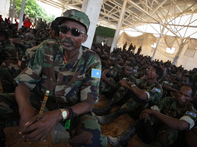 This handout picture released and taken on March 17, 2012 by the African Union-United Nations Information Support Team shows an officer from the Somali National Army (SNA) sitting with soldiers during a passing-out ceremony marking the conclusion of a 10-week advanced training course conducted by the military component of the African Union Mission in Somalia (AMISOM). Six-hundred thirty troops from different brigades of the SNA were taught and mentored on leadership skills, weapons handling field military tactics during the two and a half month course and will now deploy back to their units.