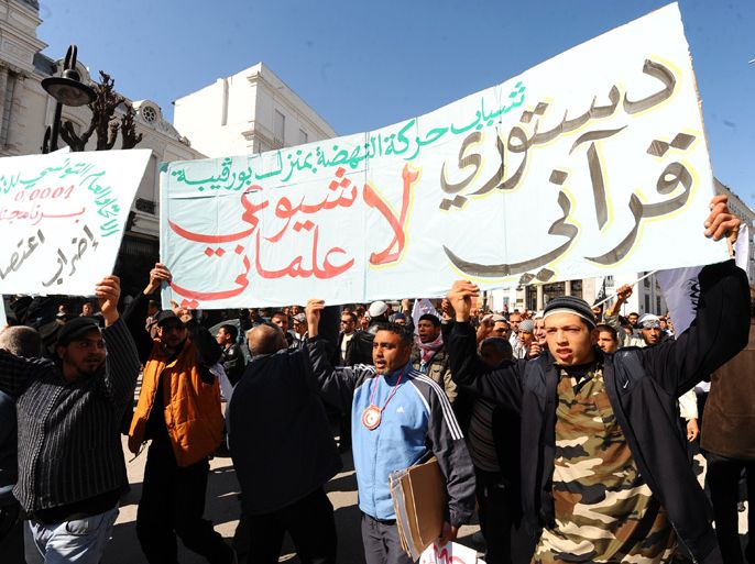 Tunisian Salafists carry a banner reading ""I am neither communist nor layman, my constitution is the Koran" while shouting slogans claiming an Islamic state as they stage a demonstration after the Friday prayer on March 2, 2012 in Tunis. AFP PHOTO / FETHI BELAID