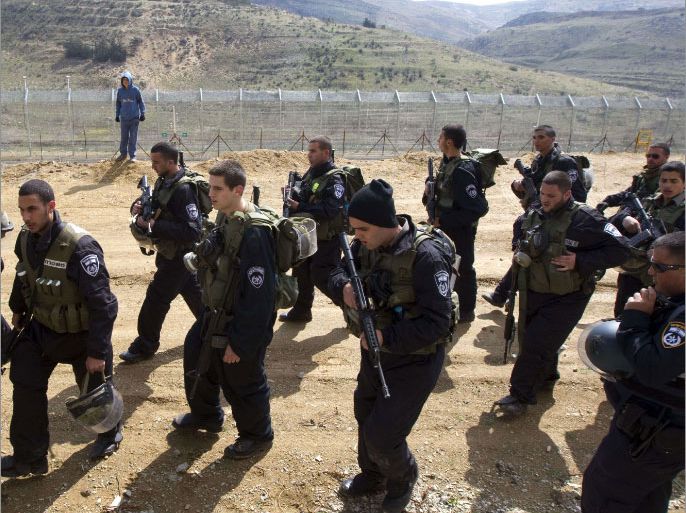 Israeli riot police patrol along the ceasefire line between the Israeli-occupied Golan Heights and Syria, in the Druze village of Majdal Shams, on March 30, 2012. People across Israel and Palestinian territories are holding a series of rallies on March 30 to mark "Land Day," which recalls an incident in 1976 when Israeli troops shot and killed six people during protests against land confiscations. TOPSHOTS AFP PHOTO/JACK GUEZ