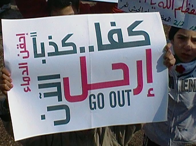 Demonstrators hold a banner that reads, "Enough lie, go out" during a protest against Syria's President Bashar al-Assad after Friday prayers in Al Qusour, Homs March 2, 2012