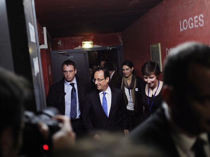 France's Socialist Party (PS) candidate for the 2012 French presidential election, Francois Hollande (C) arrives to take part in a meeting organized by several woman rights association, on March 7, 2012 in Paris, as part of his campaign. AFP PHOTO FRED DUFOUR