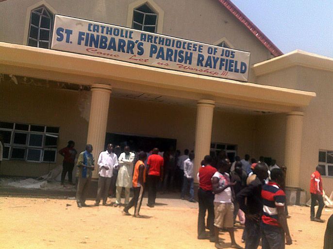 People stand outside the St Finbarr's Parish Rayfield, a Catholic church in the central Nigerian city of Jos, after a suicide bomb that killed ten people on March 11, 2012. The dead included three men shot as security forces fired on a crowd of onlookers who gathered after the blast, state government spokesman Pam Ayuba told AFP, adding that "there were 10 dead, seven parishioners and