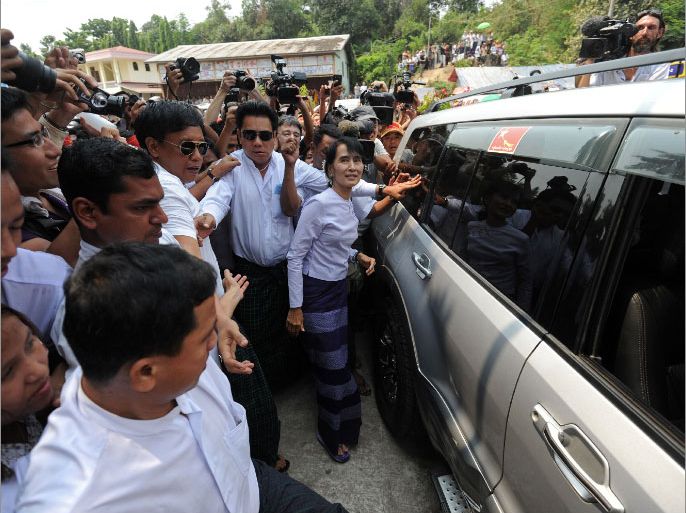 Myanmar opposition leader Aung San Suu Kyi (C) arrives to address journalists and supporters at her National League for Democracy (NLD) headquarters in Yangon on April 2, 2012. Suu Kyi hailed a "new era" for Myanmar and called for a show of political unity after her party claimed a major victory in landmark by-elections. AFP PHOTO/Soe Than WIN