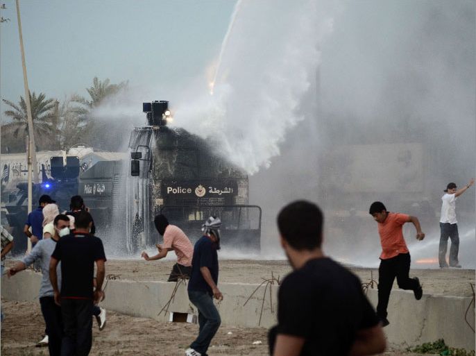 Bahraini Shiite demonstrators run for cover as riot police use a water cannon vehicle to disperse them during a protest calling for the release of a jailed activist in the village of Jidhafs, west of Manama, on April 6, 2012. Hundreds of people demonstrated in Bahrain for the release of rights activist Abdulhadi al-Khawaja who has been on hunger strike for almost two months. AFP PHOTO/STR