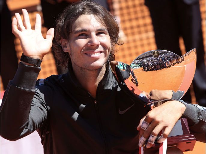 Spain's Rafael Nadal acknowledges the audience as he celebrates with his trophy after winning the Monte Carlo ATP Masters Series Tennis Tournament final against Serbia's Novak Djokovic on April 22, 2012 in Monaco. Nadal won 6-3 6-1. AFP PHOTO SEBASTIEN NOGIER