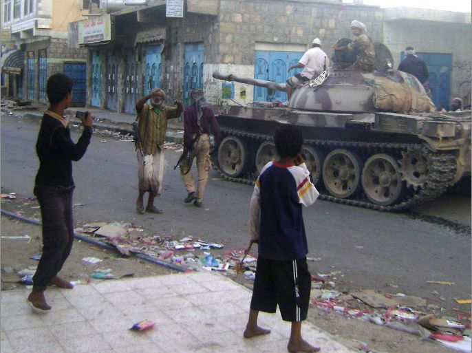 Yemeni armed tribesmen, supported by the Yemeni army to fight with Al-Qaeda militants, ride a tank in the southern town of Loder in Abyan province on April 14, 2012. According to the local sources, clashes between Yemeni armed civilians and Al-Qaeda militants trying to retake control of the town of Loder spread to nearby Mudia, as the death toll from four days of clashes reached 200. AFP PHOTO/STR