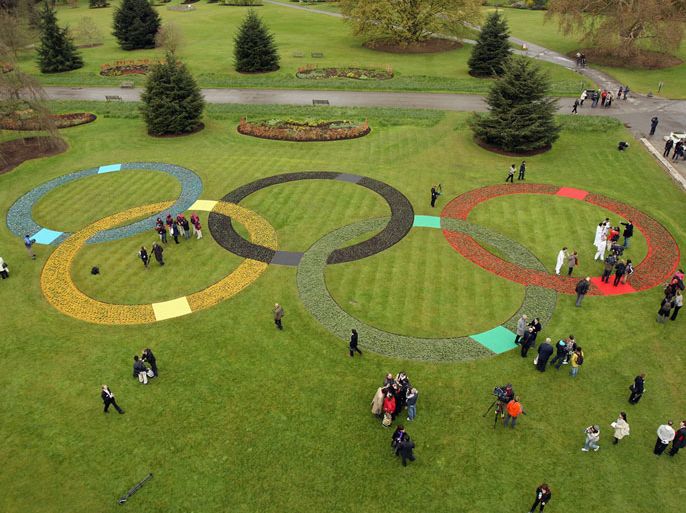 LONDON, ENGLAND - APRIL 18: Olympic officials and the media admire a large set of Olympic Rings, created with at least 20,000 flowers and plants in Kew Gardens on April 18, 2012 in London, England. The event at Kew gardens was been held to mark 100 days to go until the opening ceremony of the Olympic Games on July 27 and to announce the official motto of the London Olympics as "Inspire a generation." (Photo by Oli Scarff/Getty Images)