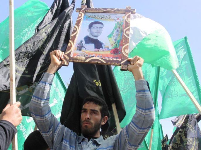 متظاهر يرفع صورة أسير مضرب عن الطعام في مسيرة حماس والجهاد بغزة